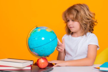 İlkokulda okuyan bir okul çocuğu. Çocuk sarı izole edilmiş arka plan üzerine ders çalışıyor. Küçük öğrenci, zeki inek öğrenci. Eğitim ve öğrenim