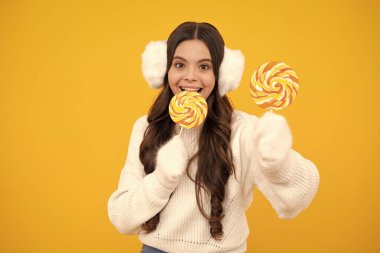 Lolipopu olan ergen bir kız, şeker yiyen bir çocuk, şekerci dükkanı olan çocuklar. Heyecanlı genç kız. Mutlu yüz, pozitif ve gülümseyen genç kız duyguları