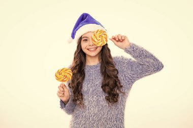 Kış kızı Noel lolipopu tutuyor. Yılbaşı süveteri içindeki genç kız beyaz tenli arka planda.