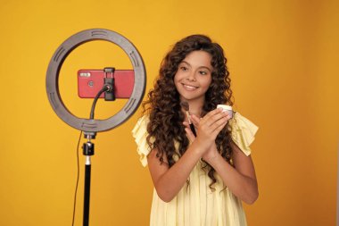 Genç çocuk akıllı telefonuyla sosyal medya için video dersi kaydediyor. Nüfuzlu genç, çevrimiçi yayınlanırken blog için yeni içerik oluşturuyor. Genç bir kızın pozitif ve gülümseyen duyguları