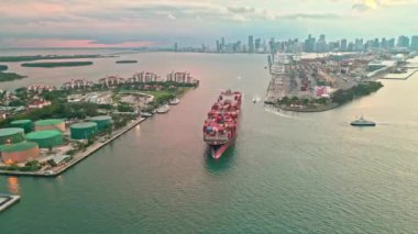 Kargo işi 4K. Konteyner gemisi. Miami 'de konteynırlı kargo gemisi, insansız hava aracı manzaralı. Konteynır Miami, Florida 'daki kargo gemisine yüklendi. Limandan ayrılan hava görüntülü kargo gemisi. Lojistik.