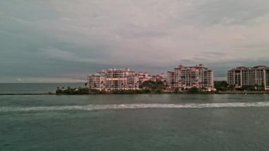 Geceleri lüks bir bina manzarası görüyorum. Akşam şehir hava manzarası. Miami 'deki lüks Fisher Adası. Akşam günbatımında şehir silüeti. Aerial Fisher Adası. Akşamları Miami plajı. Lüks oteller.