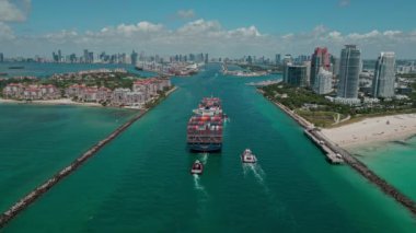Miami, Florida, ABD - 23 Haziran 2024 Miami 'de kargo gemisi, hava manzaralı. Kargo gemisindeki nakliye konteynırı Fisher Adası 'nı geçiyor. Gemi limana giriyor. Kargo terminali. Konteyner gemisi.