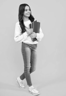 Genç kız öğrenci kitapları, not defterleri, sarı arka planda izole edilmiş, kopyalama alanı. Okula dönüş, gençlik yaşam tarzı, eğitim ve bilgi. Mutlu yüz, pozitif ve gülümseyen duygular.