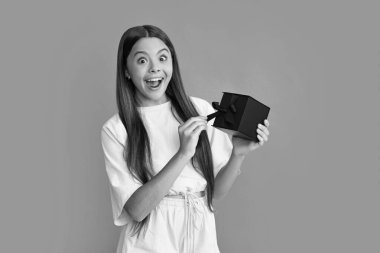 İzole edilmiş arka planda hediye kutusu olan çocuk. Doğum günü hediyeleri, sevgililer günü, yeni yıl ya da Noel. Heyecanlı bir yüz, neşeli genç bir kız.