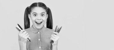 Hayretler içindeki genç kızlar resim yapmak için renkli kalemler bulundururlar. Yaratıcı bir zihin. Öğrenci portresi, stüdyo afişi. Okul çocuğu yüzü, boşluklar