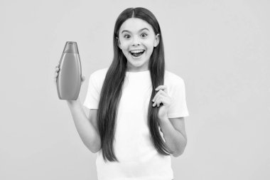 Şampuanlı ve duş jöleli genç bir kızın mutlu portresi. Genç kızın uzun saçı. Kozmetik ürünler, şampuan şişesi. Gülümseyen kız