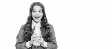 Mutlu çocuk sarı plastik şişeyi lezzetli, ferahlatıcı bir içecekle tutar, zevkle. Ayrı çocuk yüzünün yatay posteri, afiş başlığı, kopyalama alanı