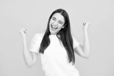 Cheerful beautiful young woman showing winner gesture. Girl celebrating crazy and amazed for success. Winner successful concept