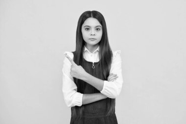 Sarı arkaplanda fotokopi alanı olan el gösteren sevimli genç kız portresi