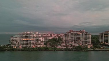 Aerial Fisher Adası. Akşamları Miami plajı. Geceleri lüks bir bina manzarası görüyorum. Akşam şehir hava manzarası. Miami 'deki lüks Fisher Adası. İHA 'dan gün batımında şehir silueti.