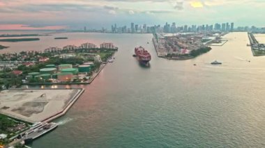 Miami marinasında kargo gemisi. Miami 'deki kargo gemisinin hava görüntüsü. Miami 'nin güney sahili kıyı şeridi hava manzarası. Günbatımı hava sahili. Akşam günbatımında marina silueti. Akşam gün batımı. Sevkiyat.