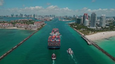 Miami, Florida, ABD - 23 Haziran 2024: kargo gemisiyle Fisher Adası 'nı geçiyoruz. Kargo gemisi. Konteyner gemisi. Miami 'de konteynırlı kargo gemisi, hava manzaralı. Nakliye lojistiği.
