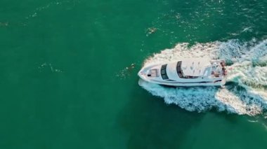 Lüks bir yaşam tarzı. Yaz tatili. Denizde yat. Sefer teknesi denizde yüzüyor. Motorlu teknenin üst görüntüsü. Denizde lüks tekne motorlu yatı. Tekne turizmi. Denizde süzülen sürat teknesi.