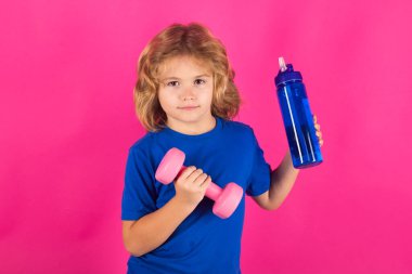 Sportif çocuklar, stüdyo portresi. Çocuk dambıllarla çalışıyor. Spor ve çocuk eğitimi.
