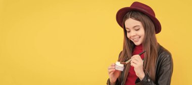 cheerful child apply face powder. teen girl hold blush. kid with makeup brush. Cosmetics for teenager child, poster design. Beauty kids makeup, banner with copy space