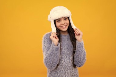 School girl in winter clothes and warm hat. Winter holiday vacation. Child fashion model. Happy teenager, positive and smiling emotions of teen girl