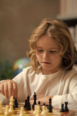 Chess school. Child think or plan about chess game in classroom. Intelligent, smart and clever school kids