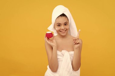 Havlulu mutlu genç çocuk yüz kremi sür..
