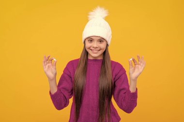 Sarı arka planda vitaminler ve gıda katkı maddeleriyle şapkalı neşeli çocuk..