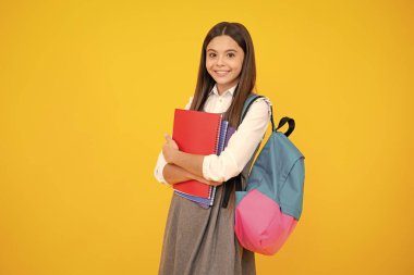 Liseli kız, genç kız, sarı izole stüdyo geçmişi üzerine kitap tutuyor. Okul ve eğitim kavramı. Okula geri dön.
