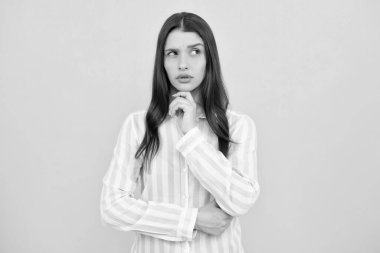 Portrait of young woman thinking, looking up empty space. Thoughtful serious model in studio looking away