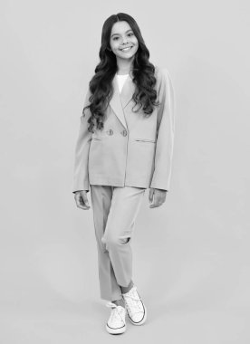 Stüdyoda sarı arka planda izole edilmiş genç kız kıyafetleri. Çocuk yaşam tarzı konsepti. Moda çocukları takımı. Mutlu ergen, pozitif ve gülümseyen genç kız duyguları