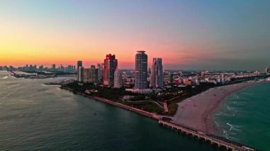 Florida 'yı aydınlattım. Canlı günbatımı renginde şehir silueti. Havadan şehir manzarası. Gece Miami South plajı. Geceleri gökdelen şehri hava manzarası. Gece şehri hava manzarası. Miami 'de lüks bir gökdelen.