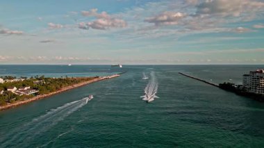 Miami marina kanalı hava görüntüleri. Denizdeki sürat teknesi. Yaz tatilinde deniz tatili. Lüks bir yat. Kanaldan Miami limanına giren tekne yatı. Miami hava manzaralı. Lüks deniz ufku ve marina..