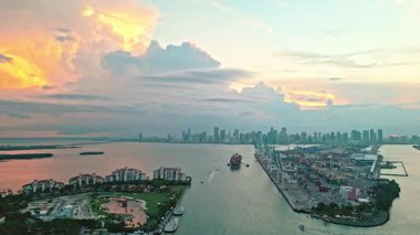 Miami 'deki geminin hava görüntüsü. Miami 'nin güney sahili kıyı şeridi hava manzarası. Günbatımı anteninden. Akşam günbatımında marina silueti. Akşam gün batımı. Dodge ve Fisher Adası. Miami marinasında kargo gemisi..