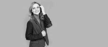 Kadın portresi, kopyalanmış başlık pankartı. Neşeli sarışın kadın iş hayatında, gri arka planda, günlük İngiliz ceketi, güzellik