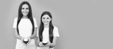 Anne ve kız çocuk afişi, kopyalama alanı, izole edilmiş arka plan. pozitif anne-kız krema kavanozunu mavi arka planda tutuyorlar.