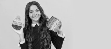 motor skills. pop it fun. happy child presenting color popit fidget. Horizontal poster of isolated child face, banner header, copy space