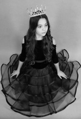 Portrait of teenage girl in ball dress with crown, feeling princess, confidence. Child princess crown on isolated studio background