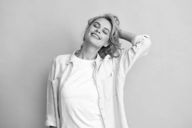 Hareketli saçlı kızıl saçlı kadın. Stüdyoda kaygısız kızıl saçlı bir kadın neşeli bir şekilde gülümsüyor canlı sarı arka planda neşeli bir şekilde.