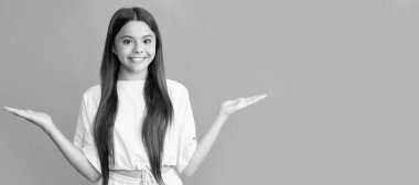 Mutlu genç kız ürün sunuyor mavi arka planda fotokopi alanı seçimi yapıyor, seçim. Çocuk yüzü, yatay poster, izole edilmiş genç kız portresi, fotokopi alanı olan pankart