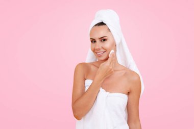Güzel kadın tenini Micellar su ve pamukla temizliyor. Sabah Güzelliği Rutini. Cilt bakımı. Temiz ciltli bir kadın pamuk ped kullanıyor. Kız yüzünü siliyor. Spa tedavileri