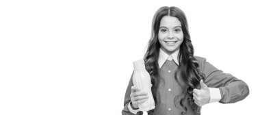 Happy kid give thumbs up hand gesture holding yellow plastic drinking bottle, approval. Horizontal poster of isolated child face, banner header, copy space