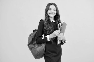 Okula dönelim. Ergen liseli kız kitaplarını ve kitaplarını öğrenmeye hazır tutuyor. İzole edilmiş sarı stüdyo geçmişi olan okul çocukları.