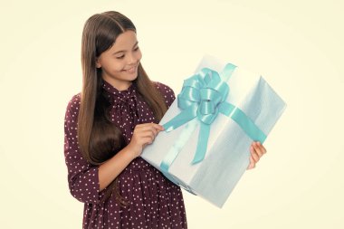 12-14 yaşlarında, izole edilmiş beyaz bir geçmişi olan bir çocuk. Doğum günü, tatil konsepti. Gençler hediye kutusunu tutar. Mutlu gülümseyen genç kızın portresi.