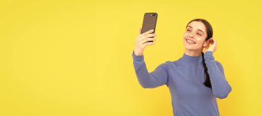İzole edilmiş yüz portresi, fotokopi alanı olan pankart. Cep telefonuyla fotoğraf çeken neşeli bir bayan, video.