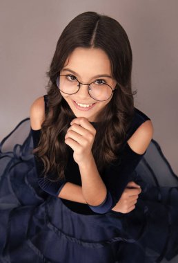 Mutlu yüz, pozitif ve gülümseyen genç kız duyguları. Gri stüdyo arka planında izole edilmiş Kafkas ergen çocuk portresi