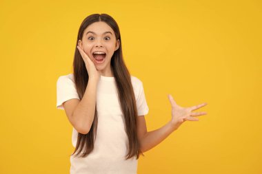 Excited teenager, glad amazed and overjoyed emotions. Amazed child with open mouth on yellow background, surprise