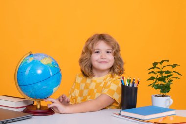 İnek öğrenci. İlkokuldan zeki bir çocuk coğrafya dersi sırasında dünyaya bakıyor. Zeki dahi zeki çocuk öğrenmeye hazır.