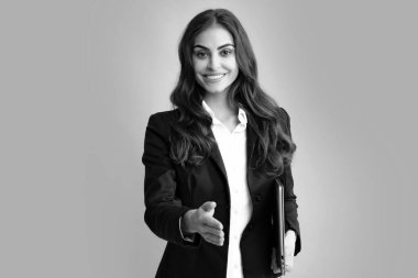Gri arka planda izole edilmiş dizüstü bilgisayar kullanan genç iş kadınının portresi. Dizüstü bilgisayarlı takım elbiseli iş kadınları. Not defteri tutan iş kadınının portresi