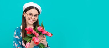 Bere takmış, laleli bir çocuk. Anneler ya da kadınlar günü. Gözlüklü çocuk çiçekleri tutuyor. Bahar çocuğu lale çiçekli bayrak, fotokopi odalı stüdyo portresi