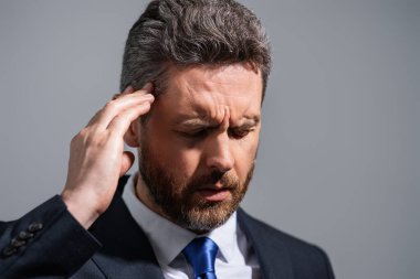 Yorgun adamın korkunç bir baş ağrısı var. Bitkin, sağlıksız hisseden, baş ağrısı hastalığına üzülen bir adam. Stresli, orta yaşlı, başı ağrıyan bir adam griden soyutlanmış. Migren ve baş ağrısı konsepti