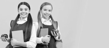 School girls friends. Expanding knowledge about healthy diet. Children hold books and apples. Banner of schoolgirl student. School child pupil portrait with copy space