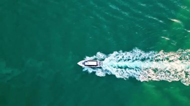 Yaz tatili, 4K çekim. Denizde yat. Sefer teknesi denizde yüzüyor. Motorlu teknenin üst görüntüsü. Denizde lüks tekne motorlu yatı. Tekne turizmi. Lüks yaşam tarzı.