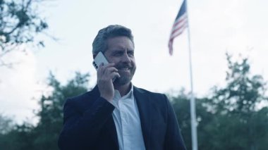 İş iletişimi açık havada. İş görüşmesi çağrısı. Patrona telefon var. İletişim ve başarılı pazarlıklar. İş adamı telefonda konuşuyor. Şirket kültürü. İş adamının telefonu var..
